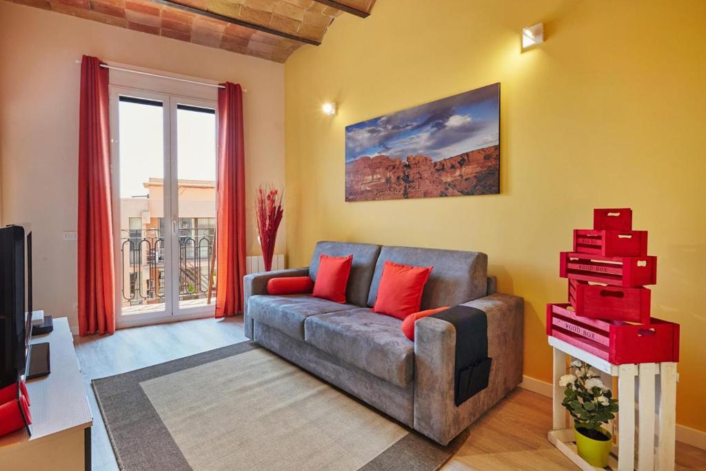 sala de estar con sofá y almohadas rojas en Lovely & bright Bogatell beach apartment, en Barcelona