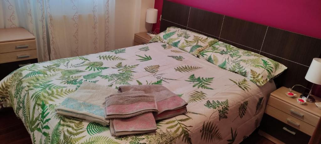 een slaapkamer met een bed met groene bladeren erop bij Apartamento vacacional en Brión, 15280 Río pego in Brion