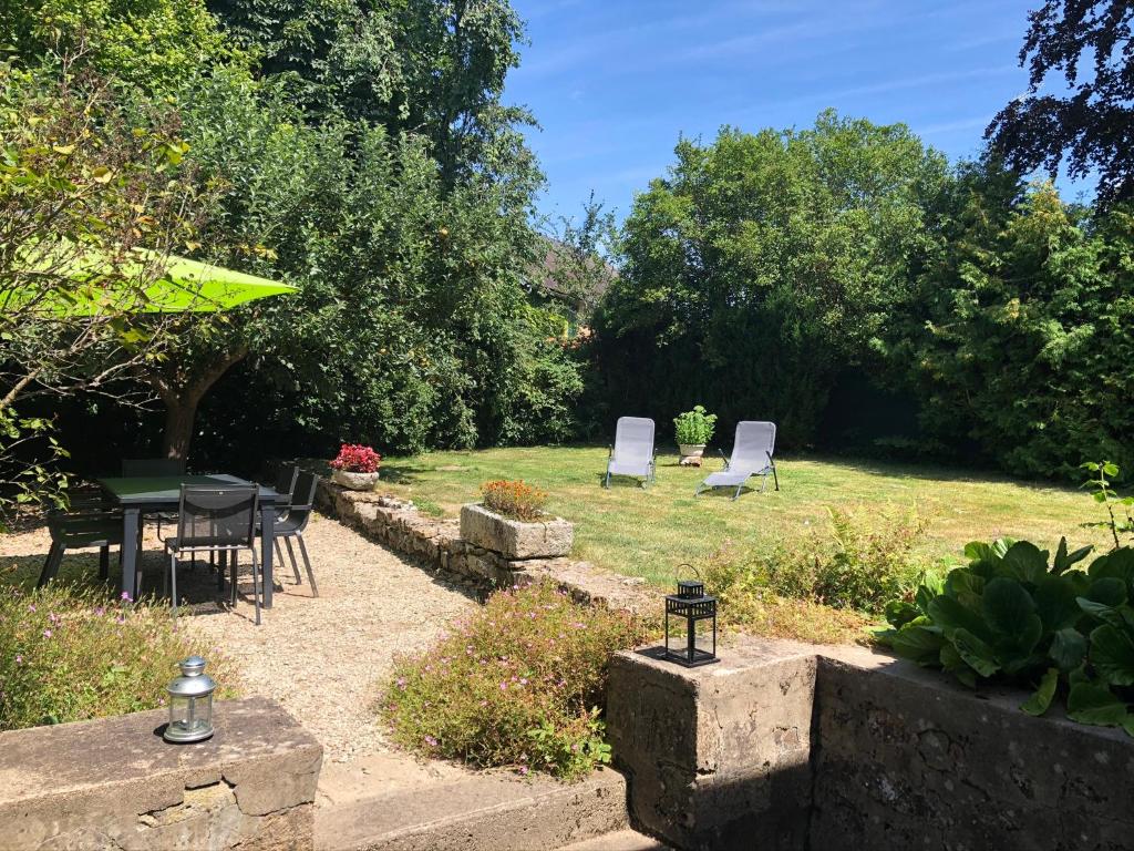 d'un jardin avec des chaises, une table et une pelouse. dans l'établissement Gîte du Manoir, à Saint-Germain-des-Champs