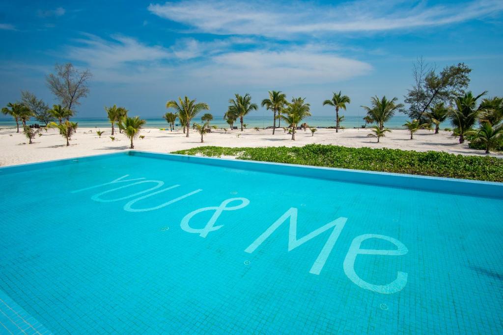 een blauw zwembad met strand op de achtergrond bij You&Me Resort in Koh Rong Island