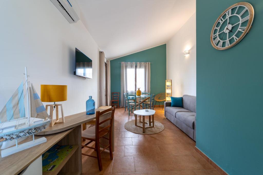 een woonkamer met een bank en een klok aan de muur bij Rif Holiday Home Stagnone Marsala in Birgi Vecchi
