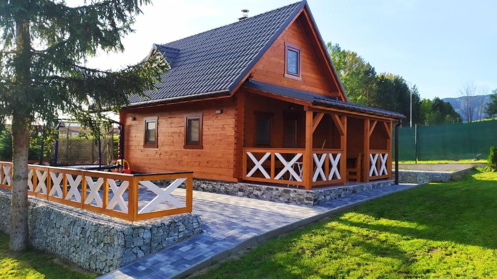 a large wooden cabin with a fence around it at Drevenička Vodníček in Liptovský Trnovec