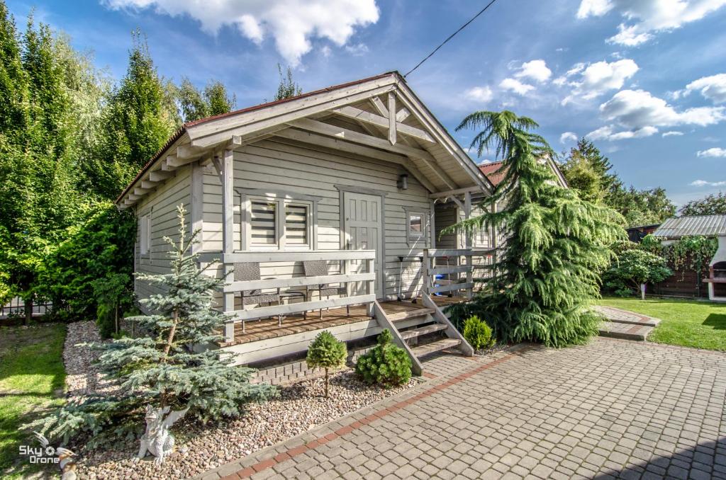 ein winziges Haus mit einer Veranda und einer Treppe in der Unterkunft szumidomek in Mielno