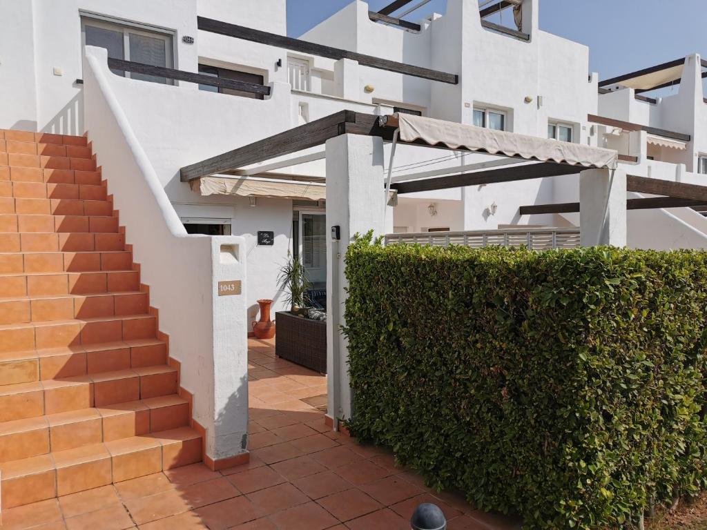 um edifício com uma escadaria e uma sebe verde em Lovely 3 Bedroom Apartment on Golf Resort em Alhama de Murcia