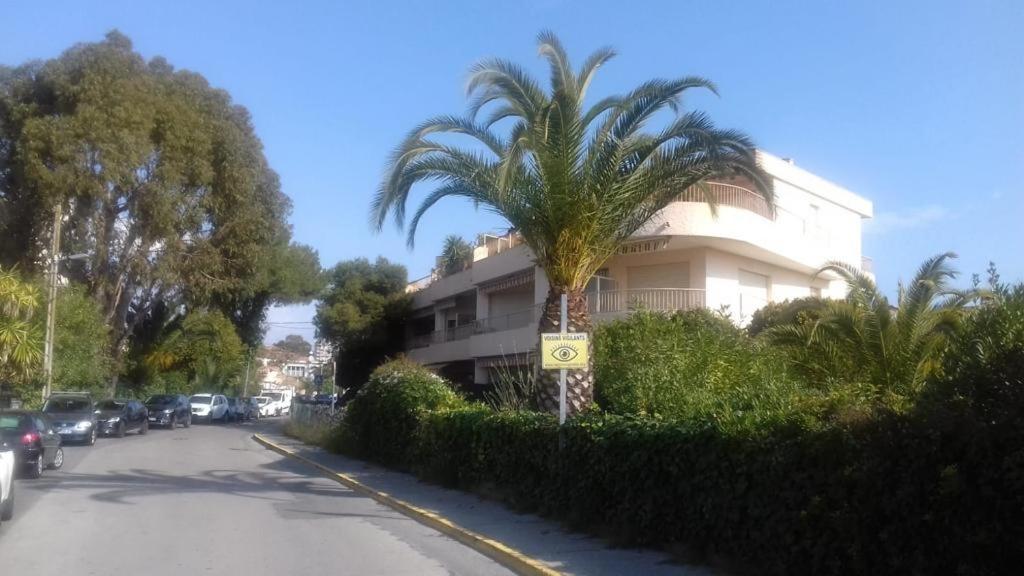 un palmier en face d'un bâtiment dans une rue dans l'établissement GOLFE JUAN 3P MER PARKING, à Vallauris