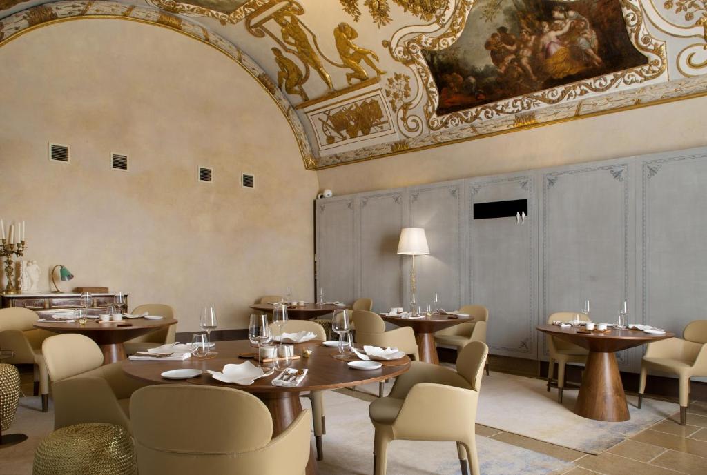 a restaurant with tables and chairs and a ceiling at Hôtel Richer De Belleval - Relais &amp; Châteaux in Montpellier