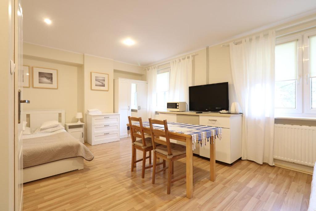 um quarto com uma mesa, uma cama e uma televisão em Wood Creek Apartments em Breslávia