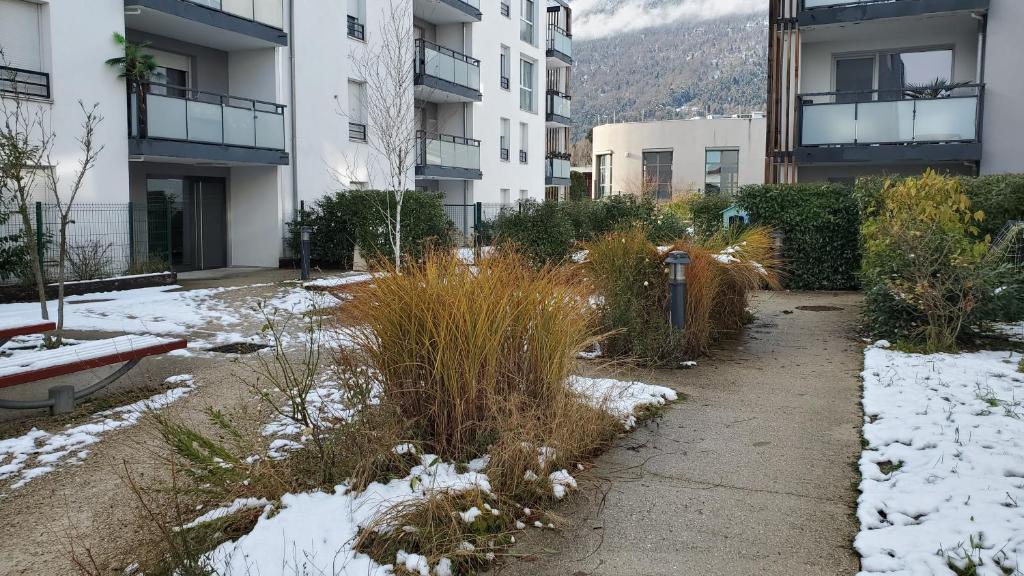 a snow covered sidewalk in front of a building at Chez' toi Gex, proche de Genève & stations de Ski in Gex