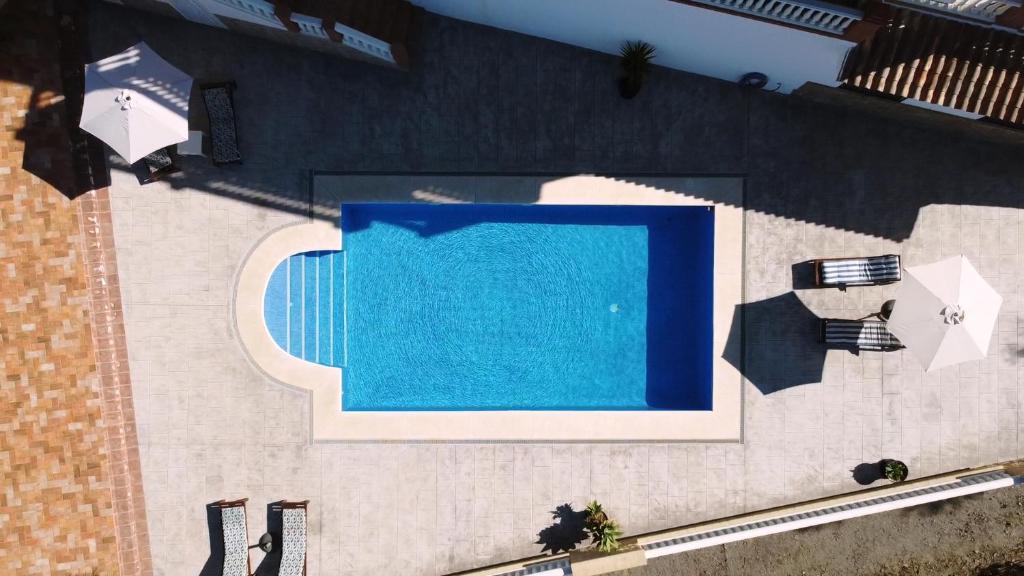 una vista aérea de una piscina azul con sombrillas en Villa El Palomar Azul with pool and sea view, en Benajarafe