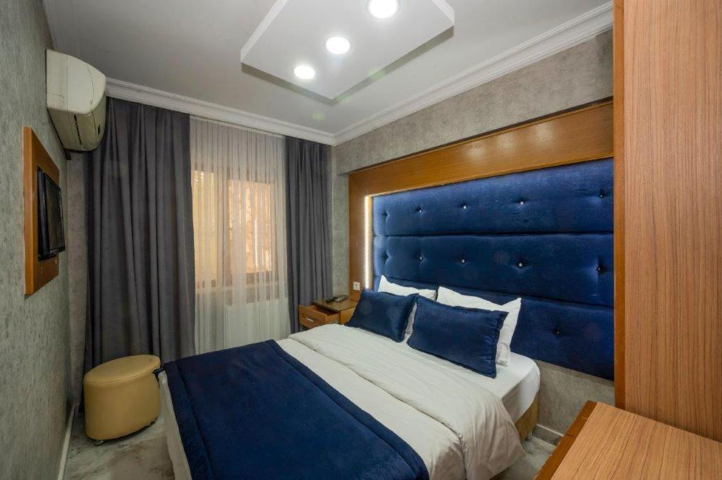 a hotel room with a bed and a blue headboard at Tamara Residence in Istanbul