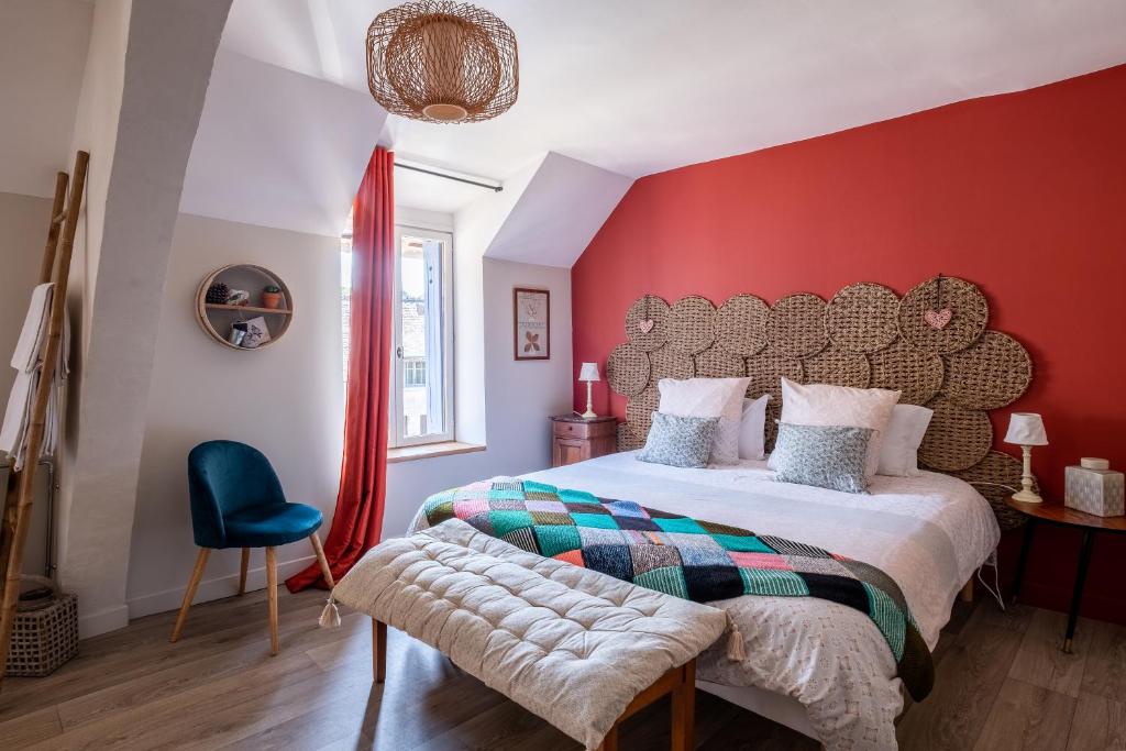 Schlafzimmer mit einem großen Bett und roten Wänden in der Unterkunft A La Lettre Thé in Molineuf