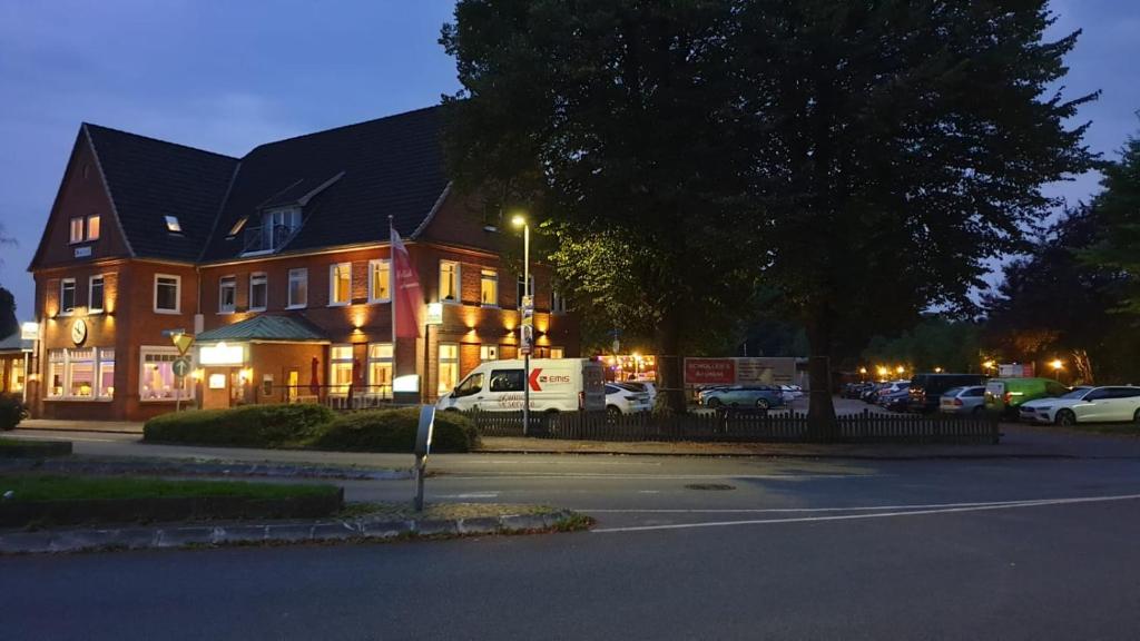 ein großes Haus mit einem Van davor geparkt in der Unterkunft Schollers Restaurant & Hotel in Rendsburg