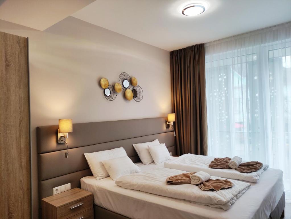ein Schlafzimmer mit einem Bett mit zwei Handtüchern darauf in der Unterkunft Spa Residence Carbona Siesta Apartman in Hévíz