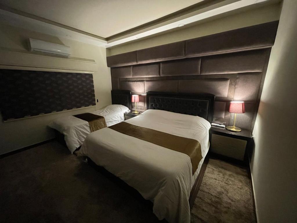 a hotel room with two beds and two lamps at Oqdeh studio in Jerash