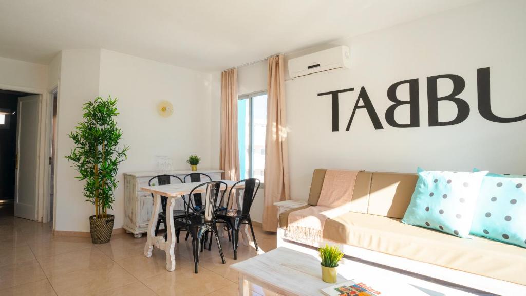 a living room with a couch and a table at Tabbu ibiza apartments in Playa d'en Bossa