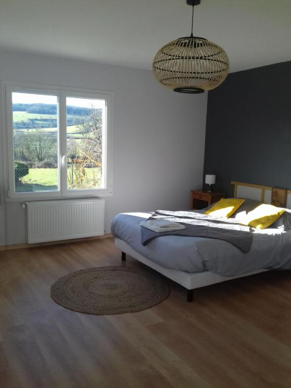 1 dormitorio con cama y ventana grande en Agréable chambre meublée, vue sur la vallée de l'Auxois en Villy-en-Auxois