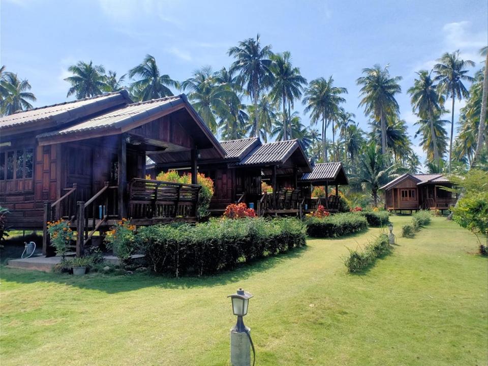 a resort with palm trees in the background at Walk in homestay in Ko Kood