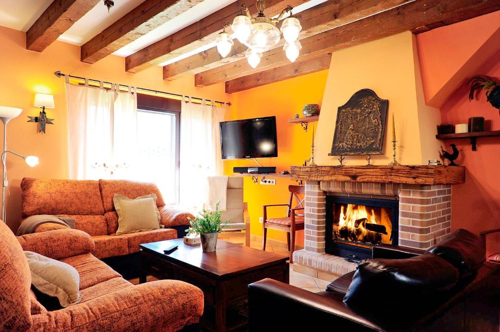a living room with a couch and a fireplace at El Valle de la Mantequilla in Aldehuela del Rincón