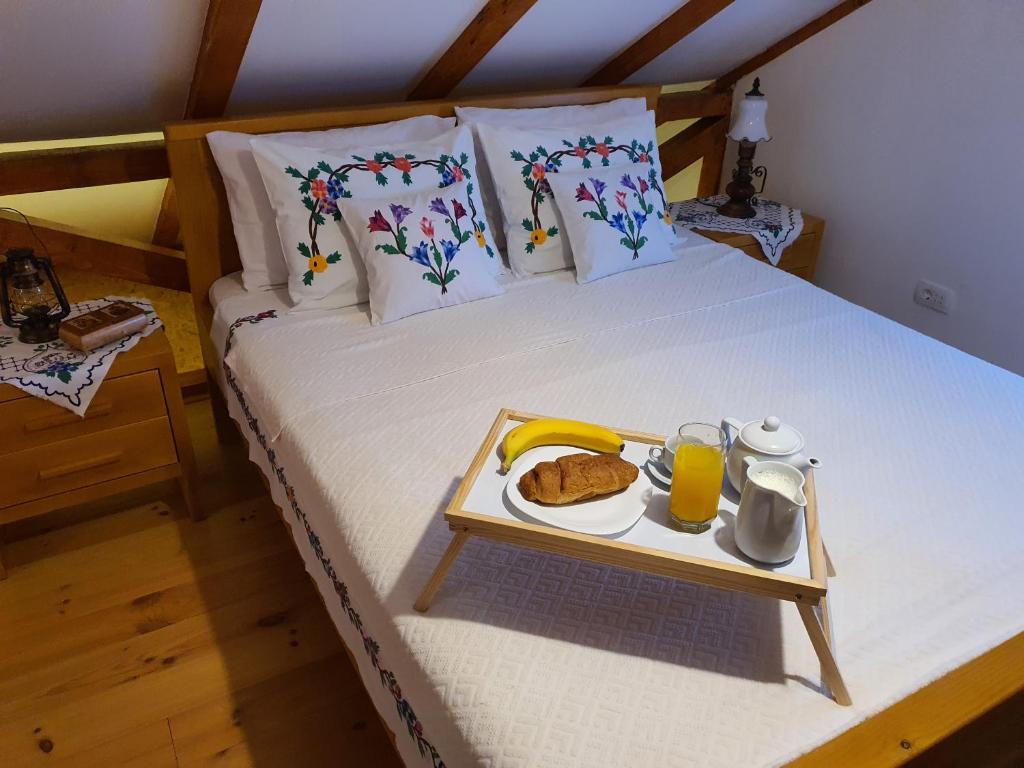 un letto con un vassoio di cibo e bevande. di Village house DUNJA a Virpazar