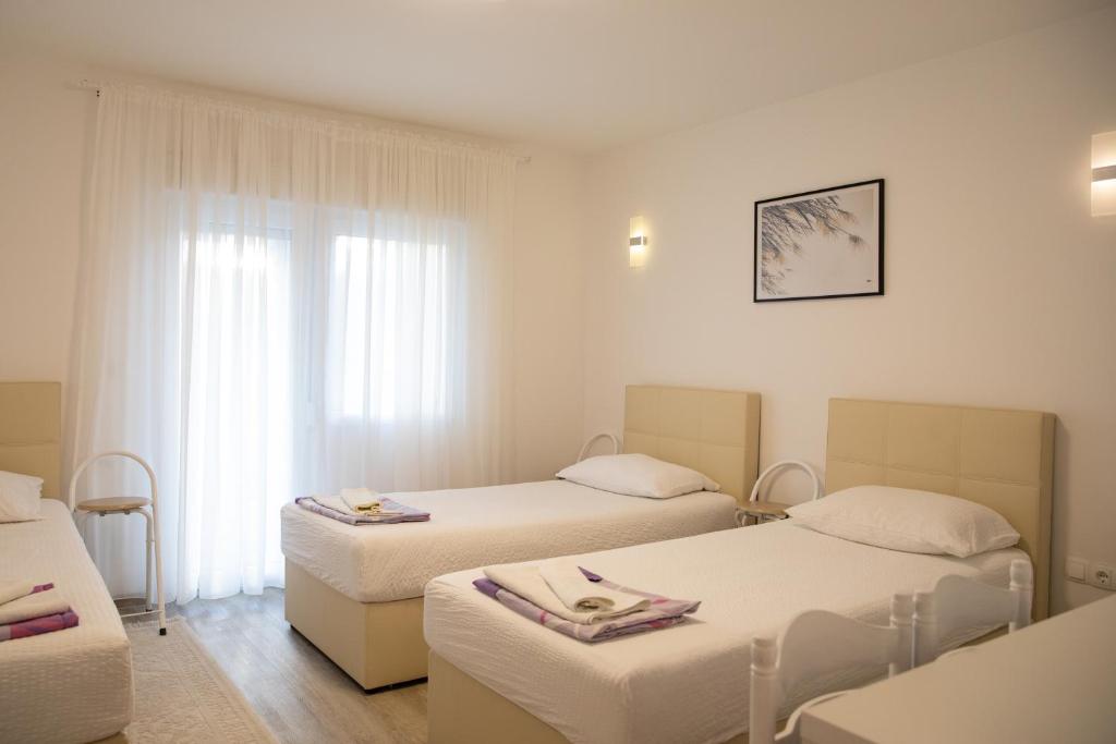 een hotelkamer met 2 bedden en een raam bij Apartment Kravica in Ljubuški