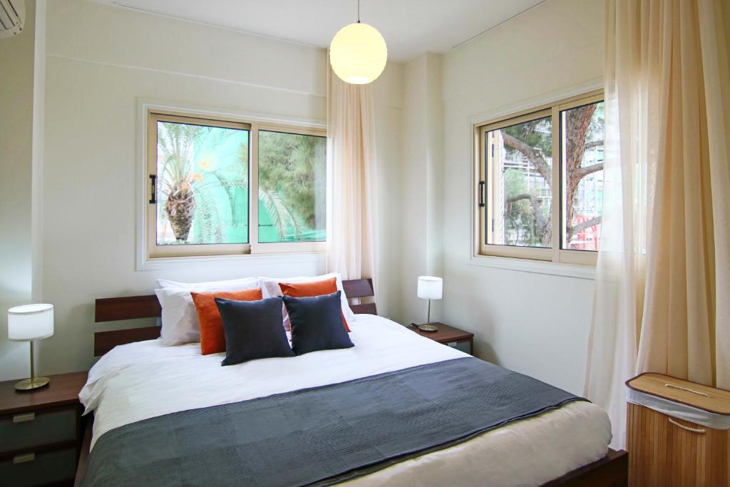 1 dormitorio con 1 cama grande y 2 ventanas en Phaedrus Living City View Luxury Iras Flat 102, en Nicosia