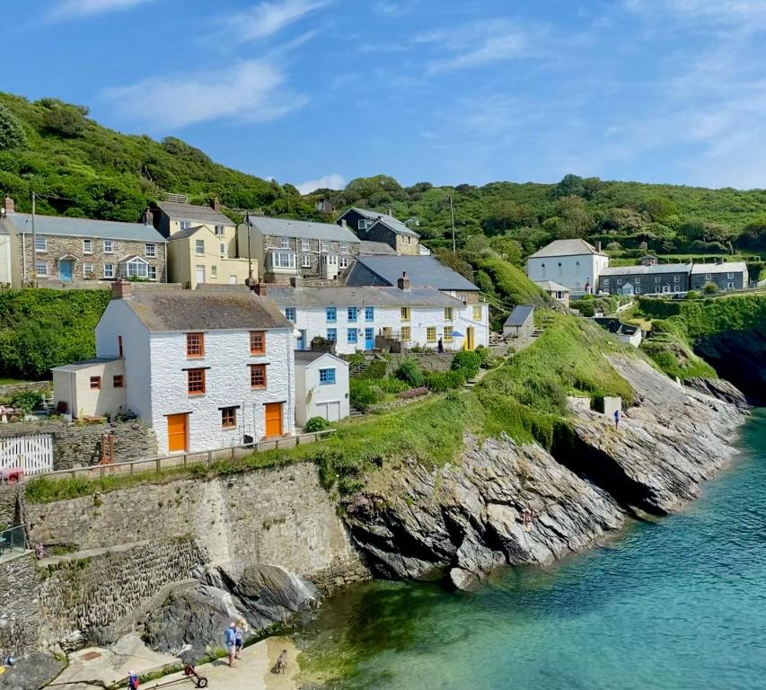 a village on the shore of a body of water at Unique Retreat - 2 bedroom cliff top cottage with large terrace in Portloe