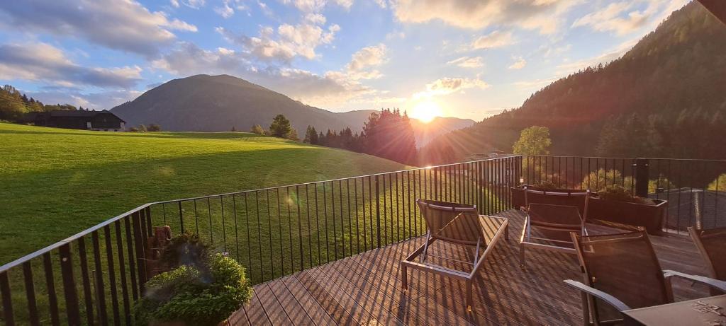 balcón con 2 sillas y vistas a la montaña en Penthouse Skyview im Natur-Erlebnispark Bad Kleinkirchheim, en Patergassen