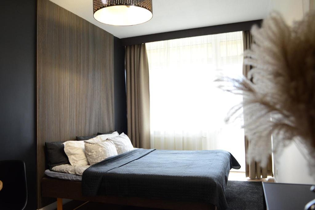 um quarto com uma cama e uma janela grande em Palanga-Apartamentai em Palanga