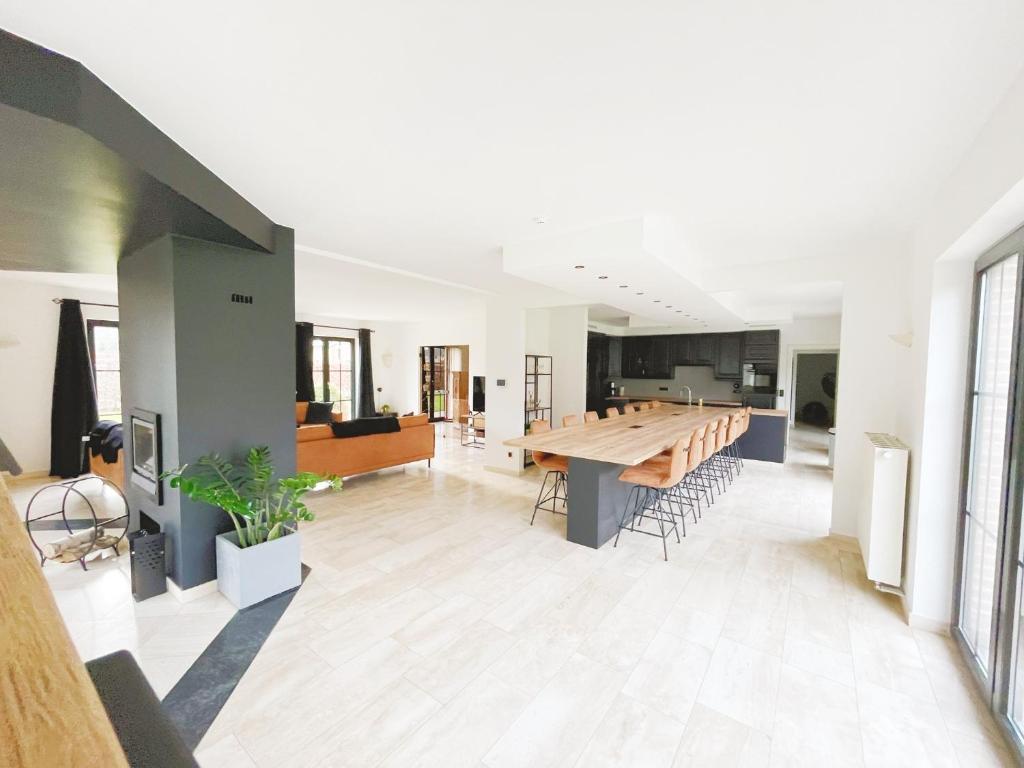 una grande cucina e una sala da pranzo con tavolo in legno di Le Pact - Gîte familial ad Anhée