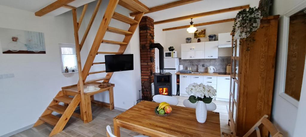 a living room with a table and a kitchen at Zacisze pod brzozami in Kętrzyn