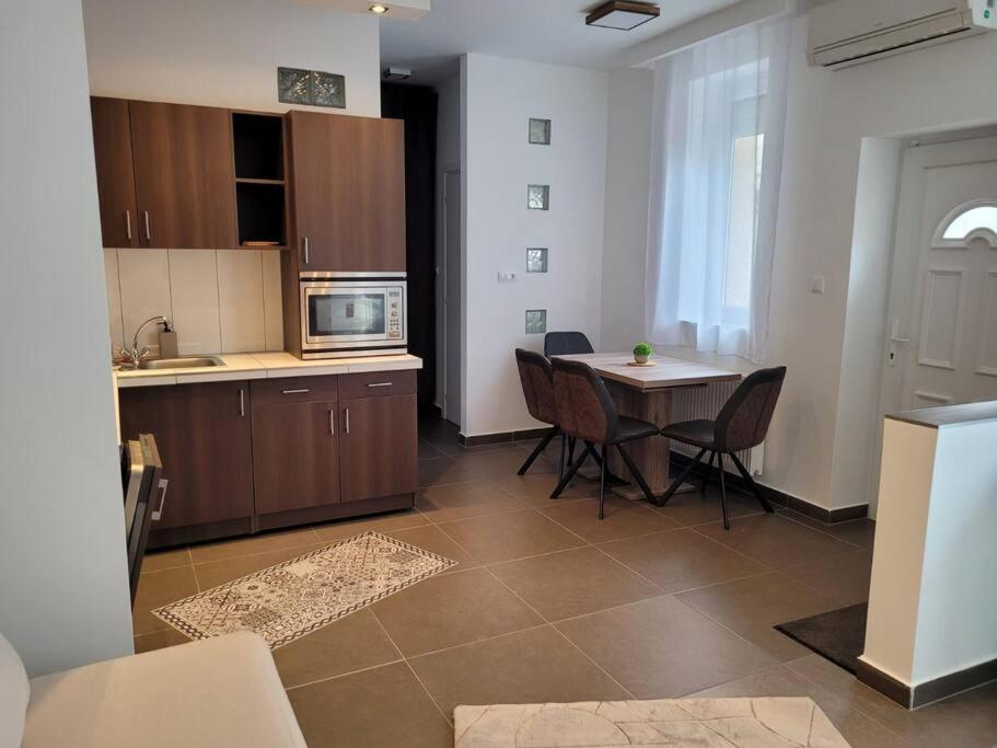 - une cuisine et une salle à manger avec une table et des chaises dans l'établissement Lovely Apartment with free parking, à Kecskemét