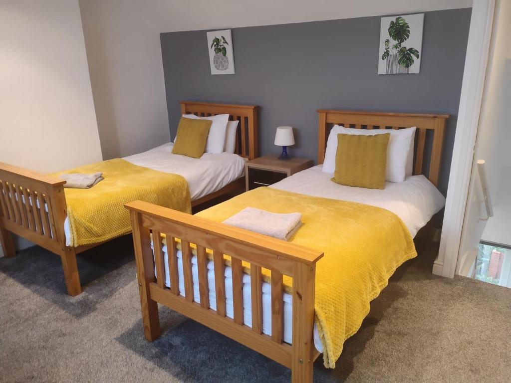 2 letti con lenzuola gialle in una stanza di Buller View a York