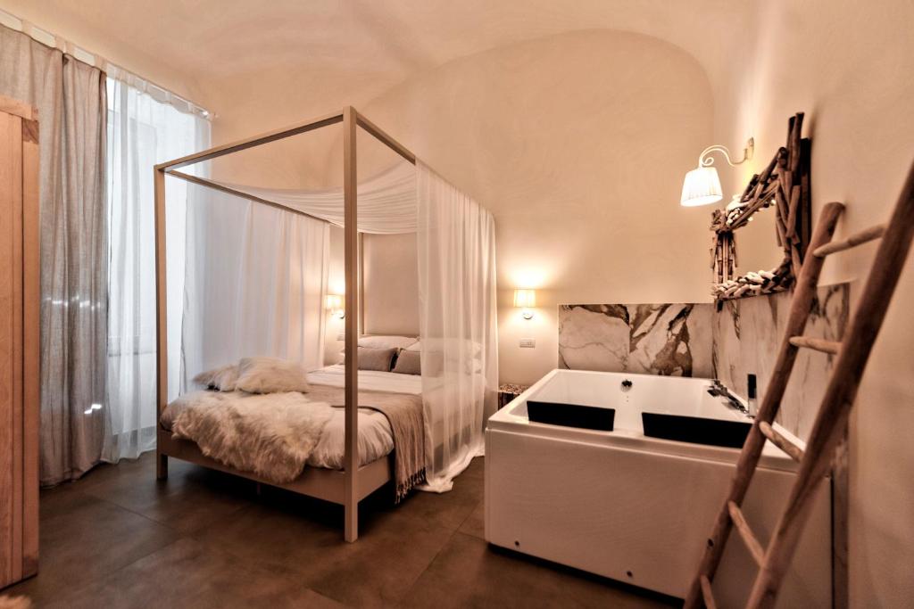a bedroom with a canopy bed and a bath tub at Terra Mia Suite in Pompei