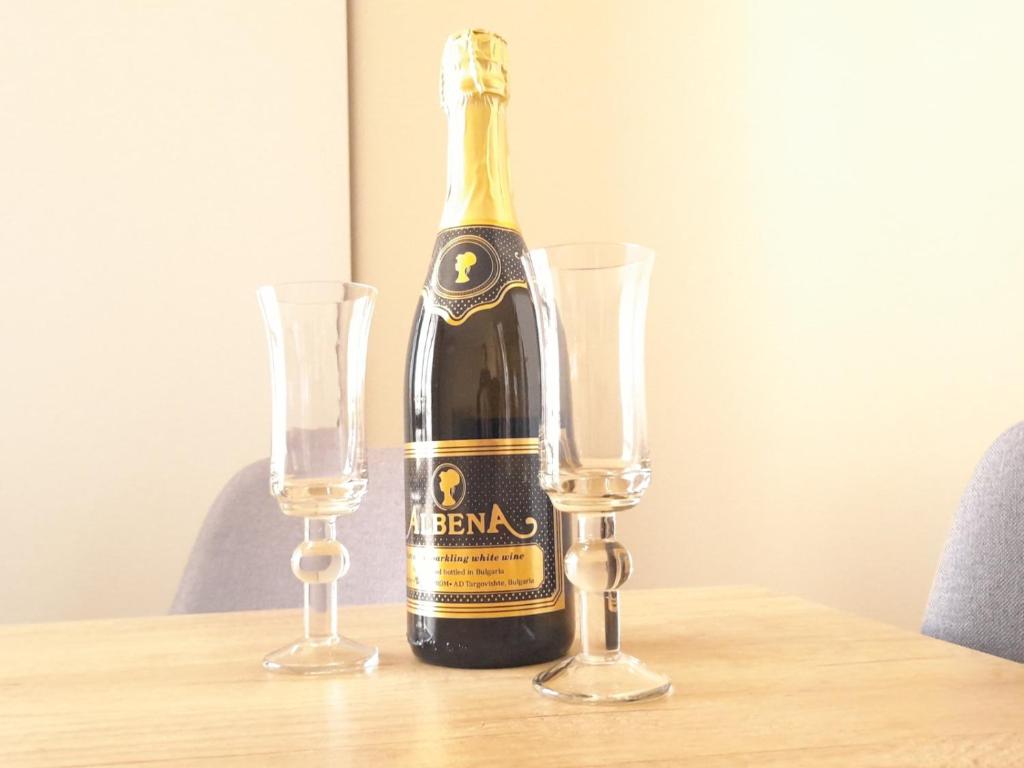 uma garrafa de champanhe sentada numa mesa com dois copos em Sea Dreams Apartment em Sveti Vlas