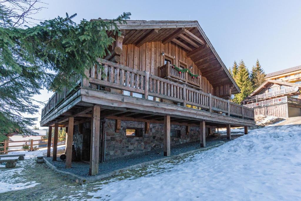 ein großes Holzhaus mit einer Terrasse im Schnee in der Unterkunft Chalet Vancouver in Donovaly
