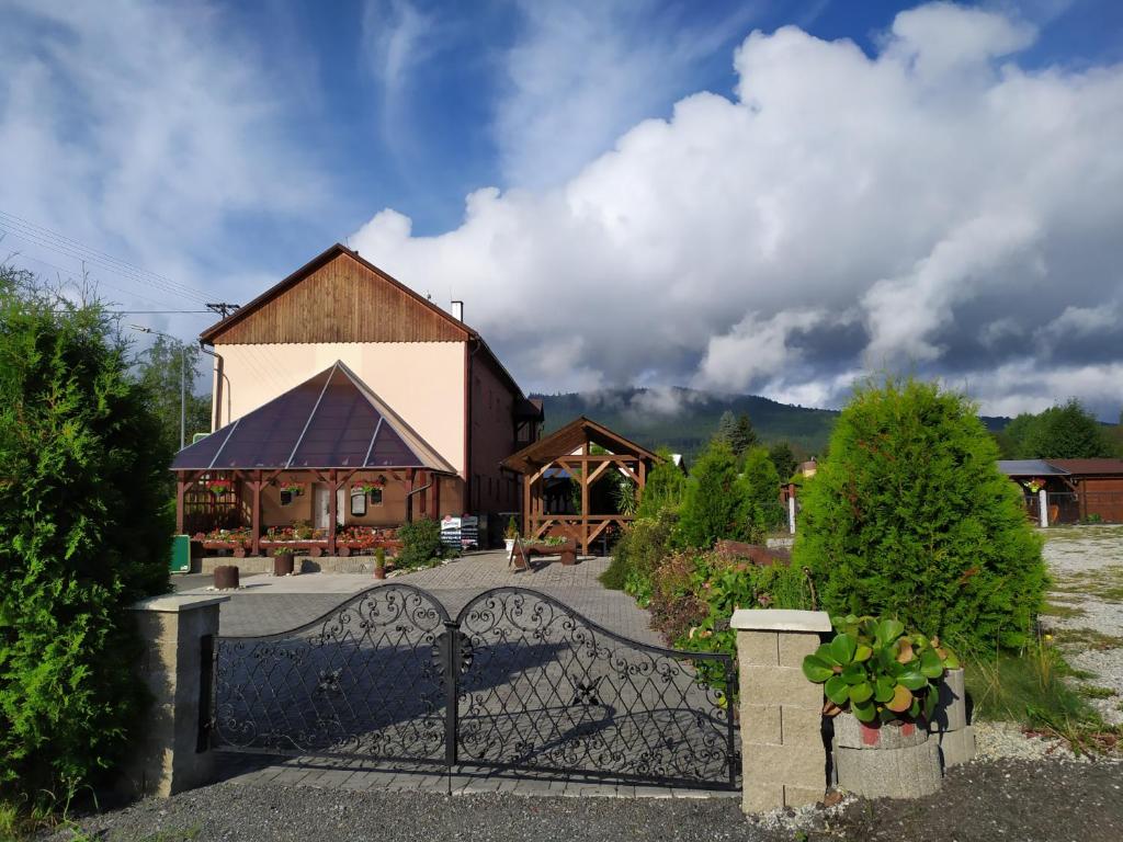 ein Haus mit einem Tor vor einem Gebäude in der Unterkunft Pension Motel Anna in Lenora