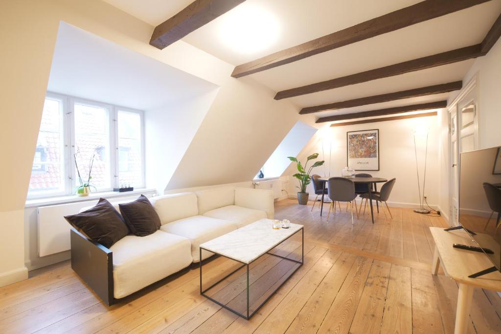 a living room with a white couch and a table at Admiral's Apartment IV - Carolina's apartments in Copenhagen