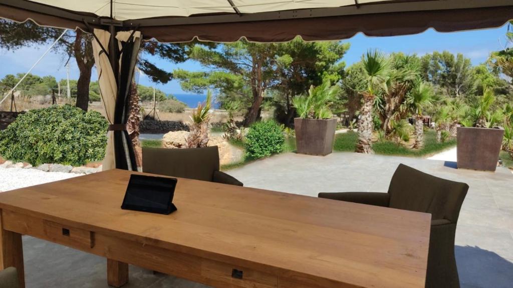 聖維托羅卡波的住宿－Araja Villa&Suite by Geocharme，一张坐在木桌边的笔记本电脑