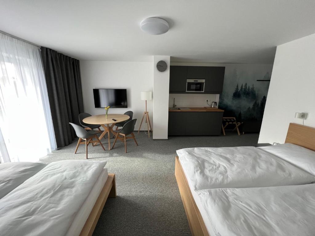 Habitación de hotel con cama, mesa y sillas en HOTEL VARNSDORF en Varnsdorf