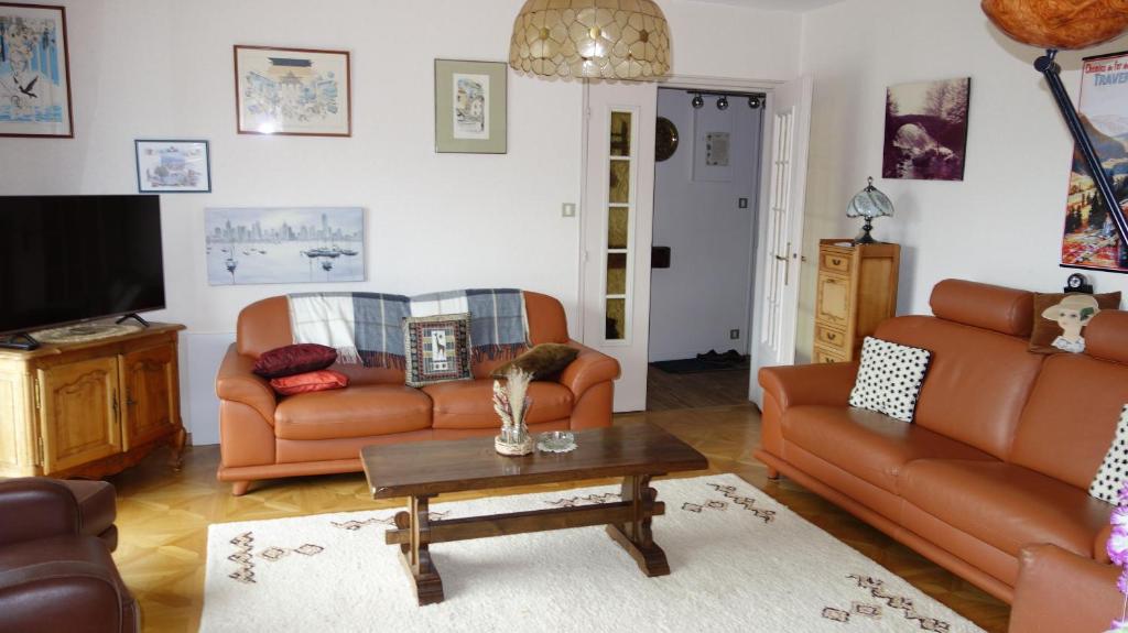 ein Wohnzimmer mit 2 Sofas und einem Couchtisch in der Unterkunft Les Naïades in Gérardmer