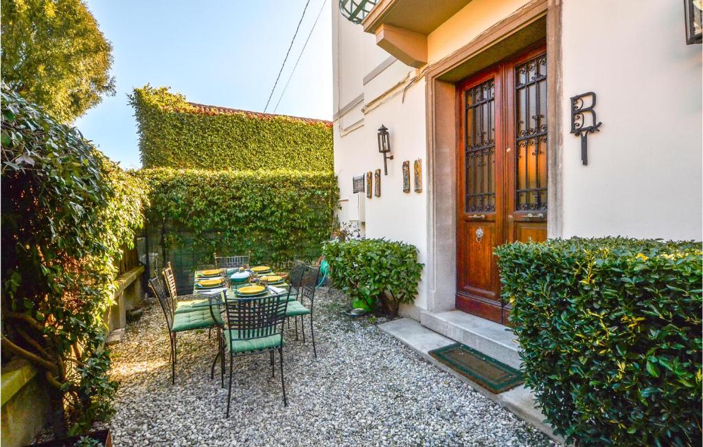 un patio con tavolo e sedie di fronte a un edificio di Amazing Home In Lido Di Venezia With Kitchen a Lido di Venezia