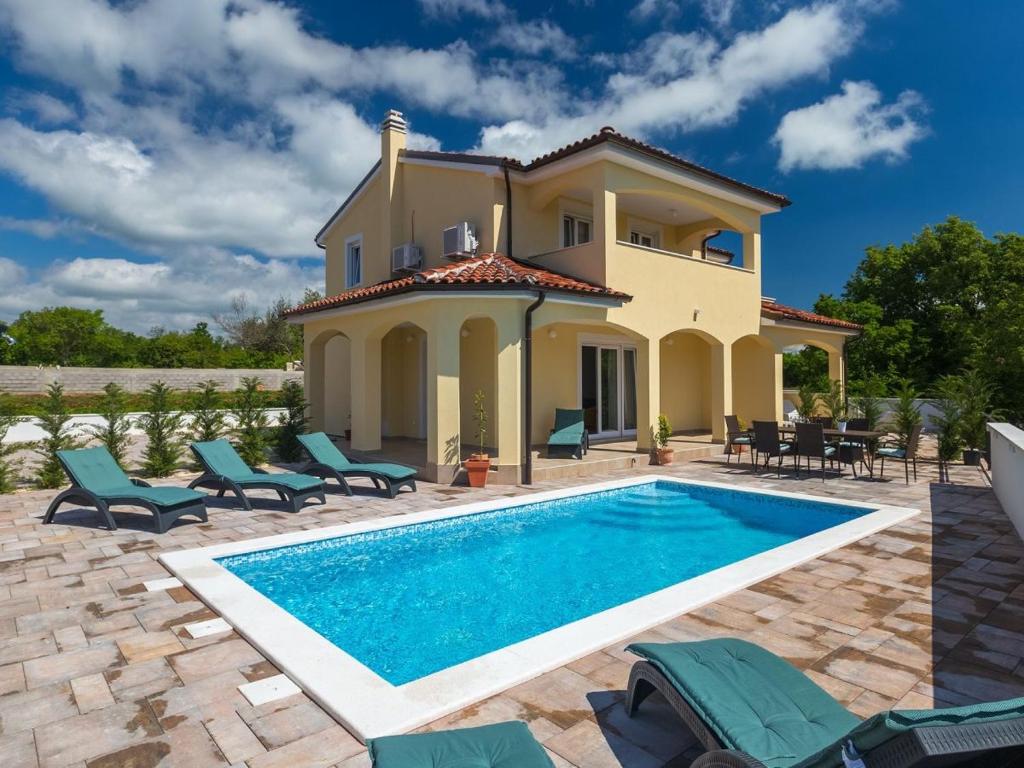 uma villa com piscina em frente a uma casa em Villa Florami em Krnica