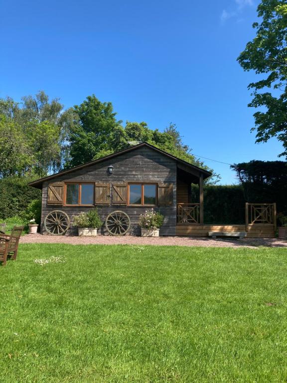 a log cabin with a green lawn in front of it at Domaine des Thyllères,Chalet Colvert in Beaufour