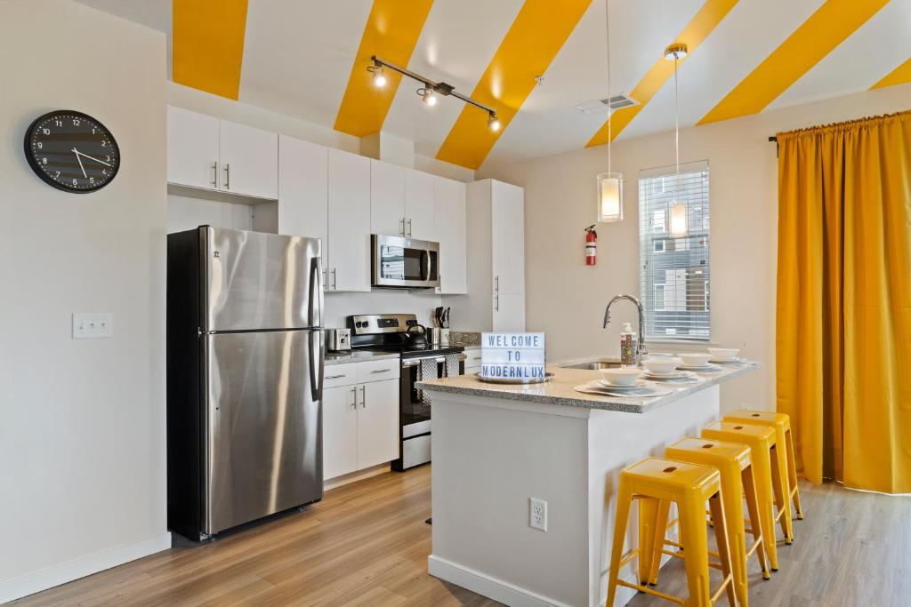 a kitchen with a stainless steel refrigerator and white cabinets at Modern Home 2BR 2BA Free Off-Street Parking & Wifi in Baltimore