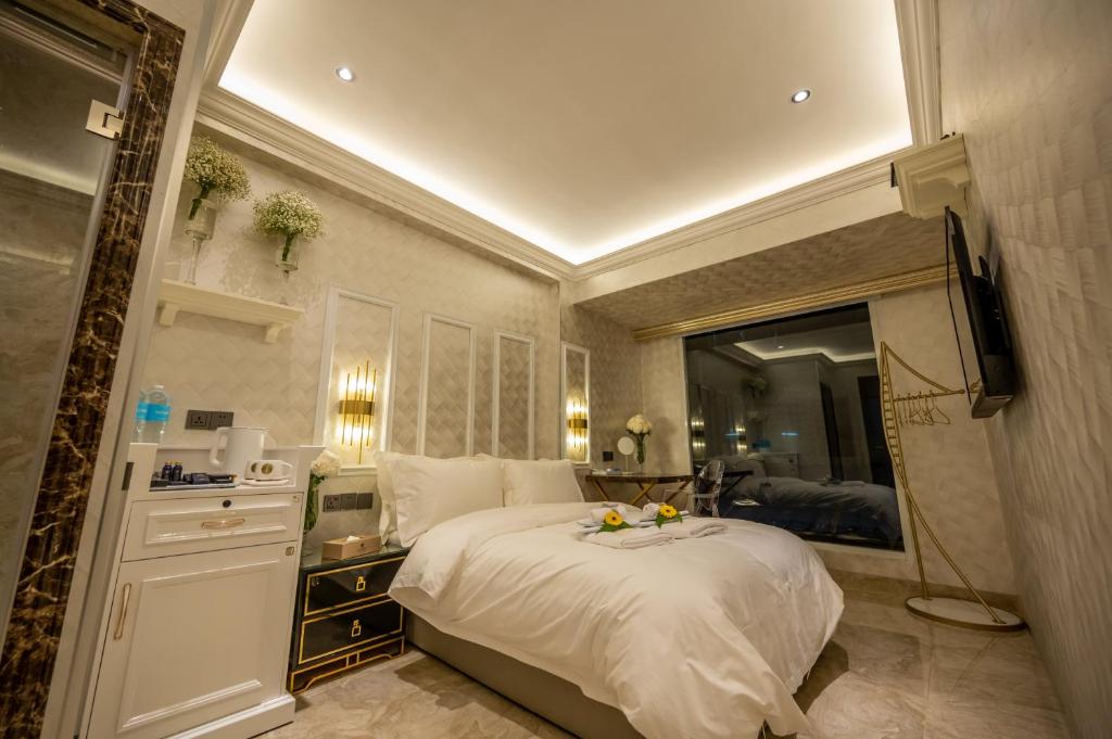 A Residence @ Between Hilton & Cititel Hotel في كوتا كينابالو: غرفة نوم بسرير ابيض كبير ومرآة