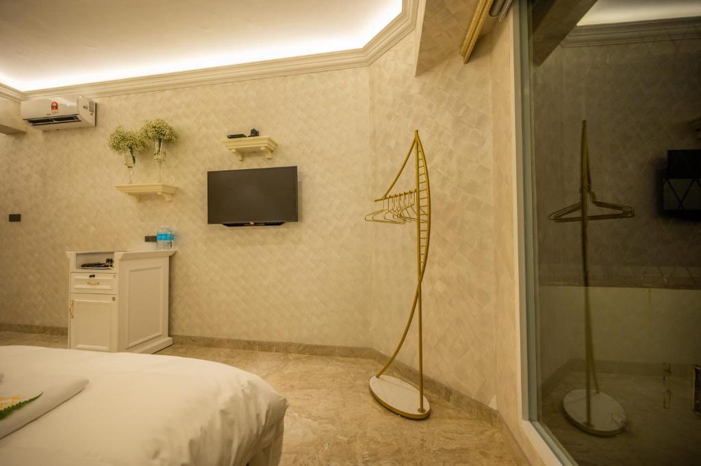 a bedroom with a shower and a television on the wall at ACJ Residence @ Beside Cititel Hotel in Kota Kinabalu