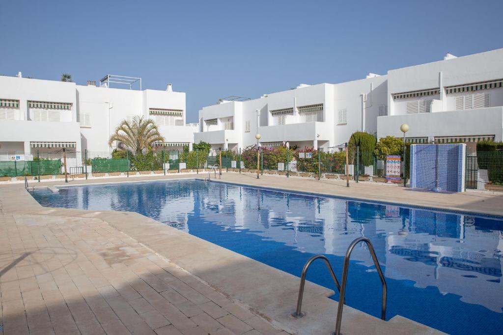 une grande piscine en face d'un bâtiment dans l'établissement Casa 64 - 2 Bedroom Penthouse At Las Marinas, Vera Playa, à Vera