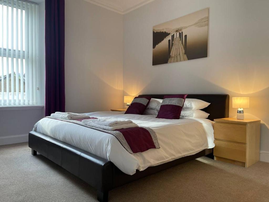 a bedroom with a large bed with pillows and a night stand at Apartment 39c in Oban