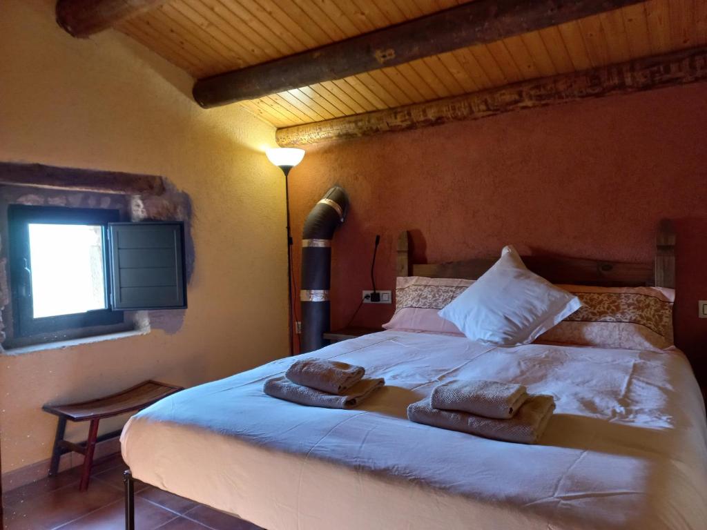 a bedroom with a bed with two towels on it at Cal Calçó in Pinós