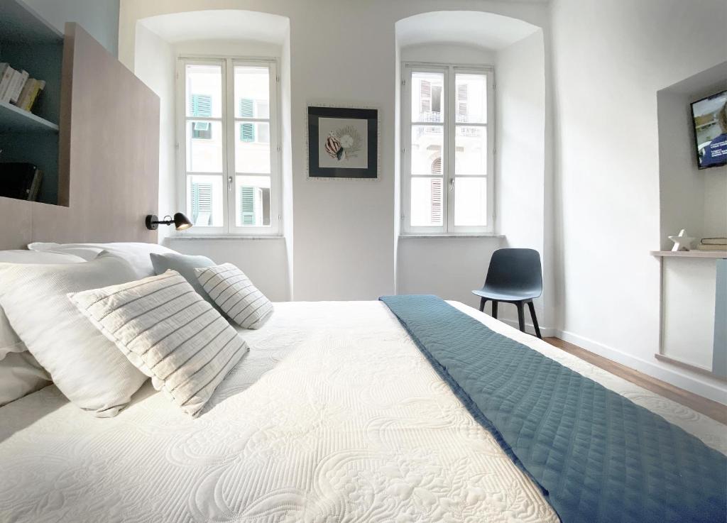 a bedroom with a large white bed and two windows at Affittacamere del Prione in La Spezia